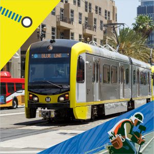 Light rail train on street with bus in background.