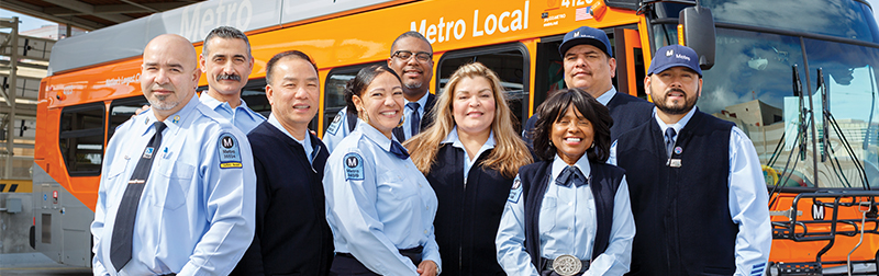 Group of Metro Bus Operators posing in front of a bus