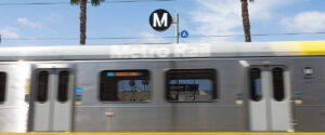 Metro Line A (Blue) train passing quickly in front of A Line sign.