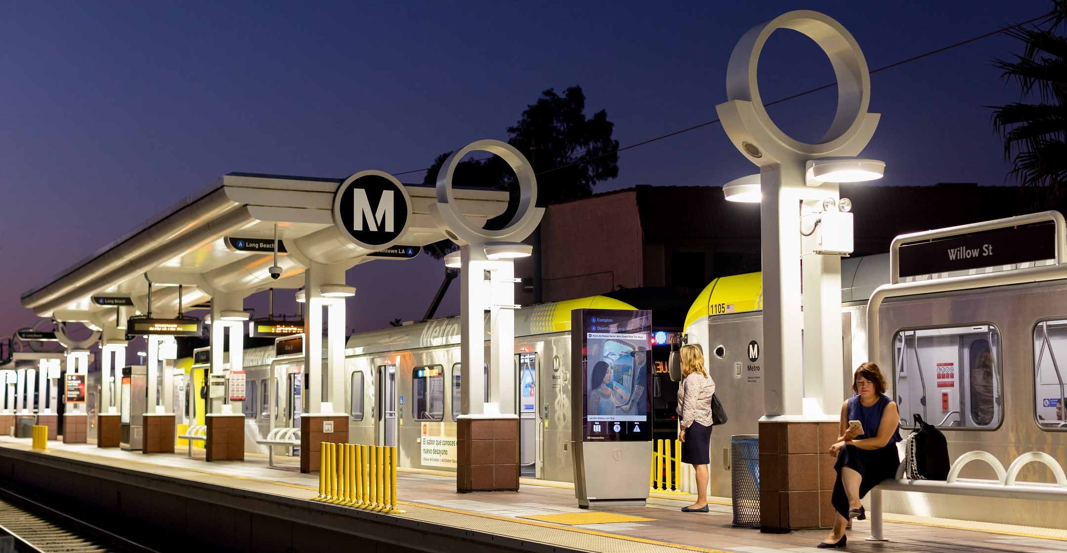 Metro Art Kiosk Willow Station with Train and passengers on the platform.