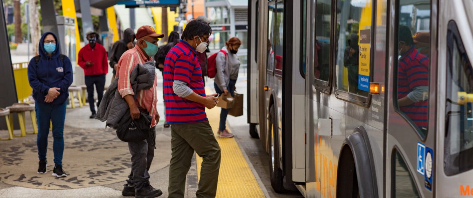 Passengers boarding Metro bus wearing protective masks.