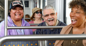 Senior riders laughing while riding a Metro light rail vehicle.