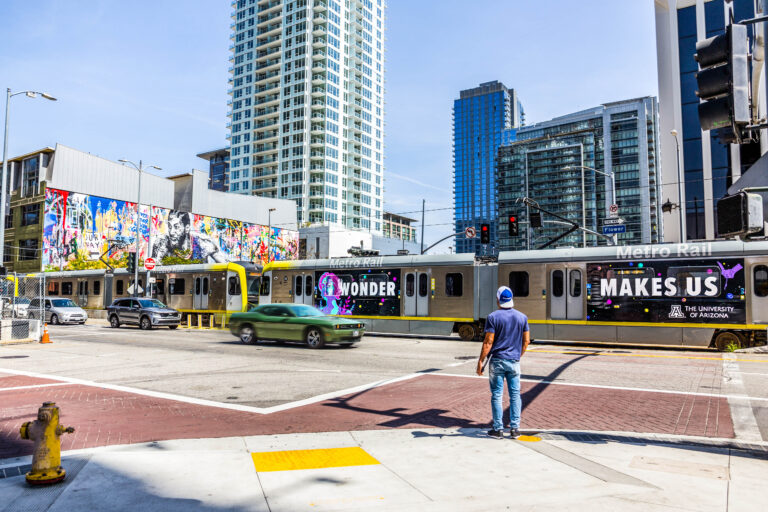 Metro Rail vehicle passing through intersection at Flower St featuring Los Angeles Rail Train Wrap.