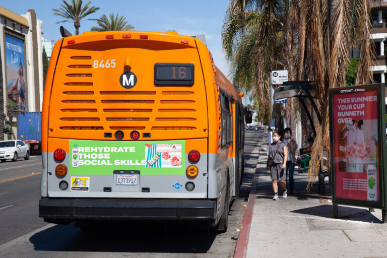 Rear view of Metro Local Bus with passengers boarding the 16 line with Bus Tail ad.