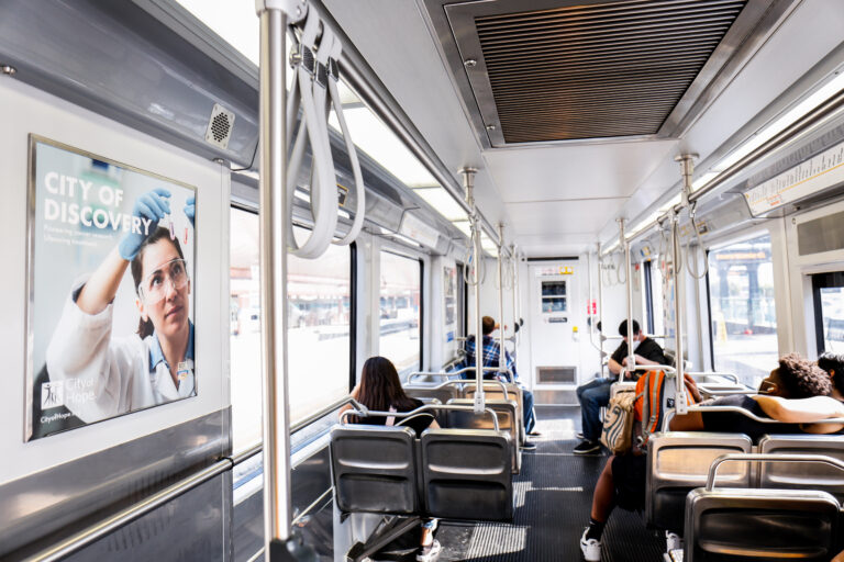 Passengers on Metro Rail Light Rail Interior Car Card on left.