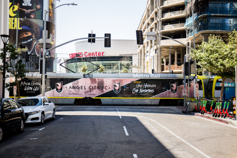 Metro Rail vehicle passing through intersection featuring Los Angeles Rail Train Wrap.