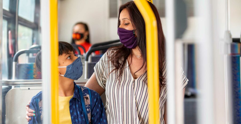 Mother hugging her child wearing masks on Metro vehicle.